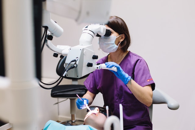 A dentist treating patient using medical equipment