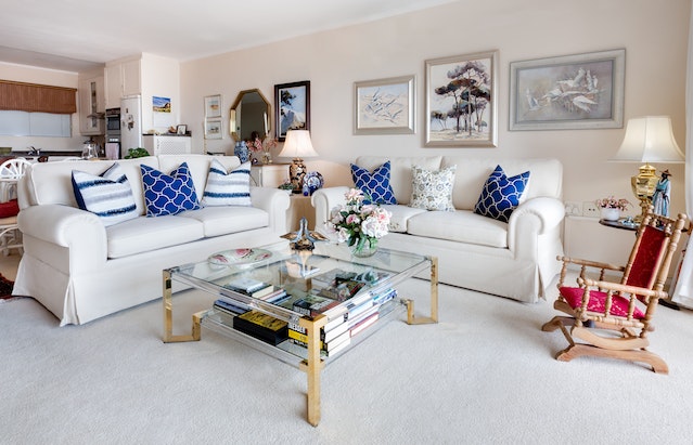 Beautiful home design with Coffee Table, Two White Leather 2-seat Sofas, lamp, photo frames and books